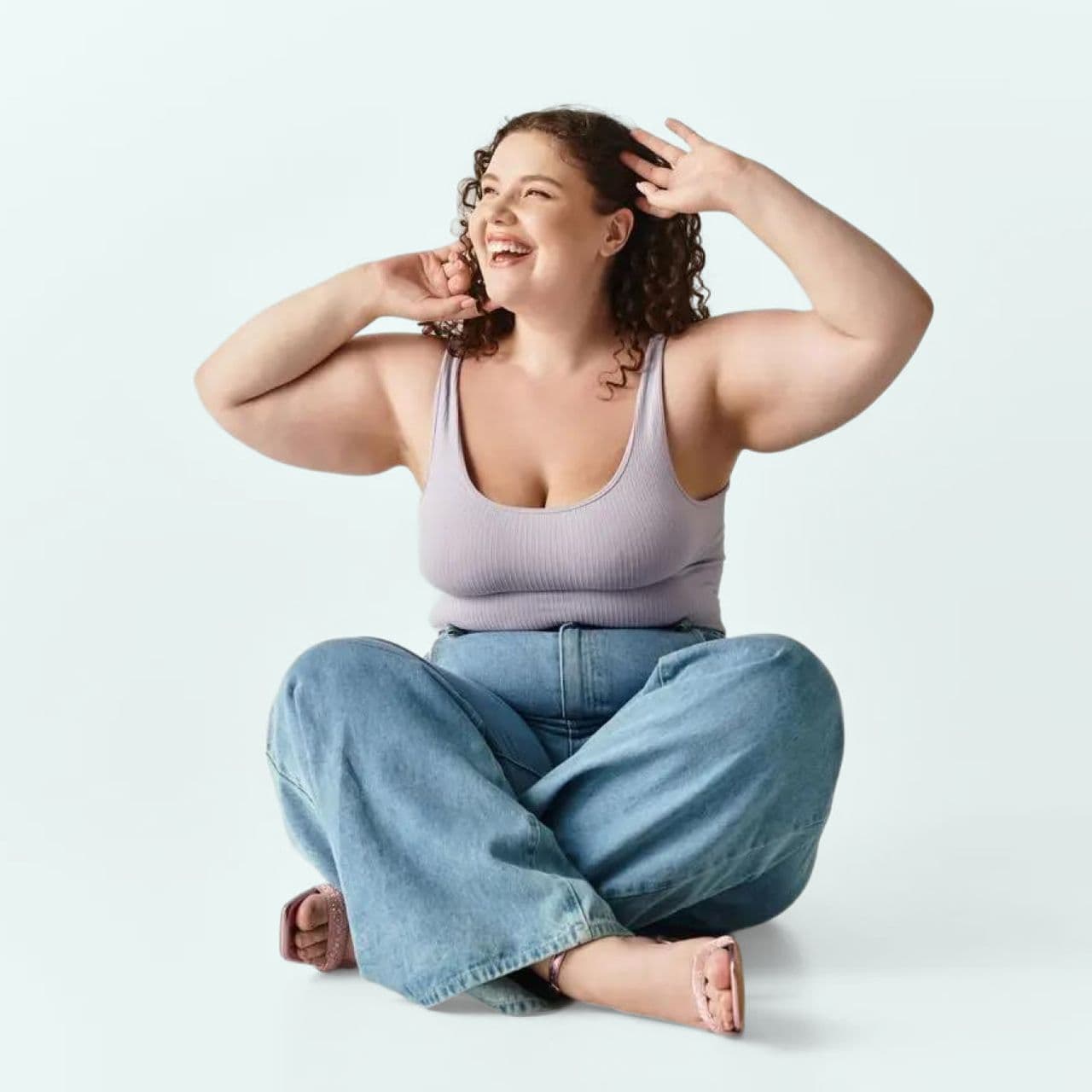 About us image - woman sitting cross legged with a blue background.